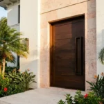 Elegant modern exterior door with warm wood tones and minimalist landscaping for Florida homes