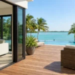 Folding impact glass doors opening to waterfront deck in a Miami Beach luxury home.