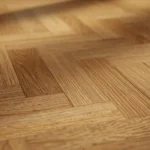 Herringbone-pattern wood flooring showcasing precision craftsmanship and rich texture