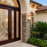 Sophisticated exterior door with clear glass panels and elegant landscaping for Florida homes
