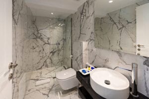 interior of a luxury bathroom with marble walls and shower cabin