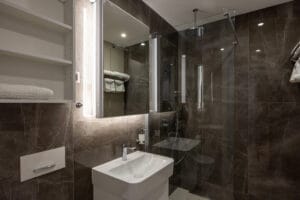 bathroom interior with brown marble wall and glass shower cabin