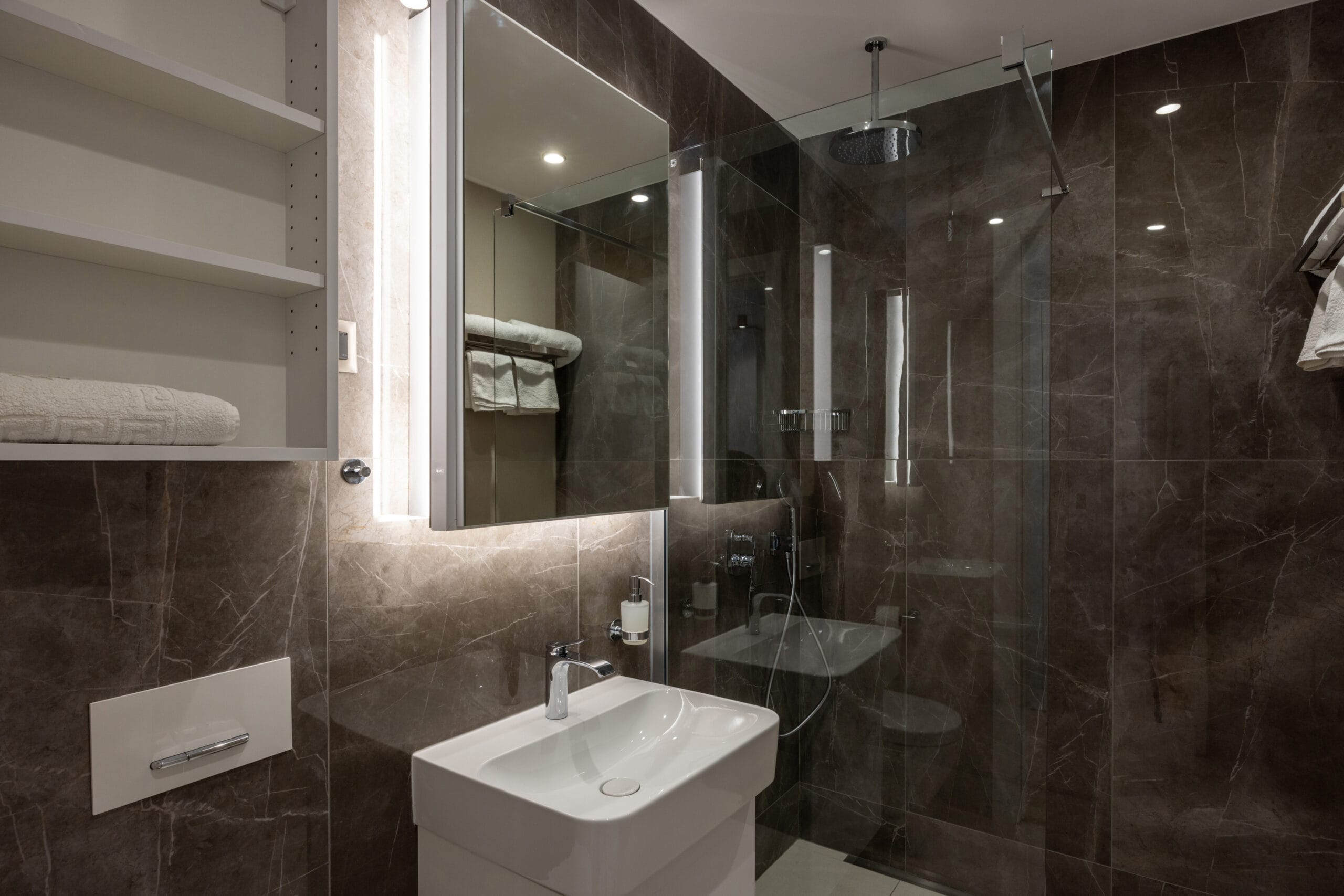 bathroom interior with brown marble wall and glass shower cabin