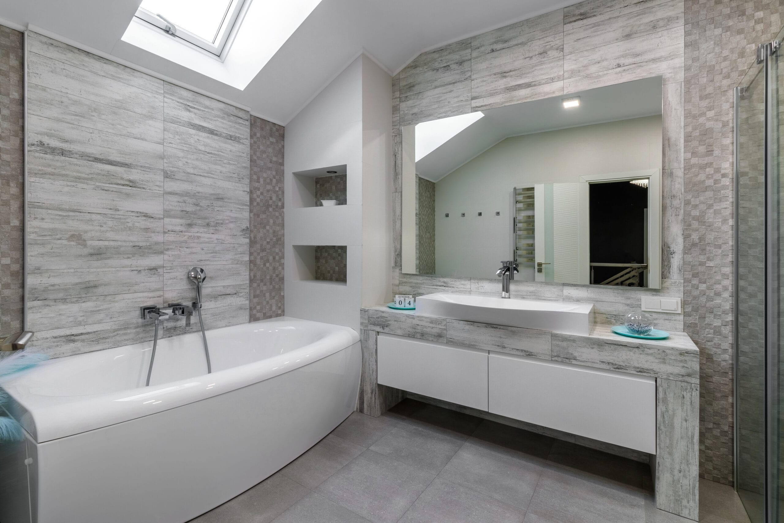 bathroom with a shower cabin, a large mirror and a chrome heater or a radiator of a towel against a white wall. loft style in a new apartment